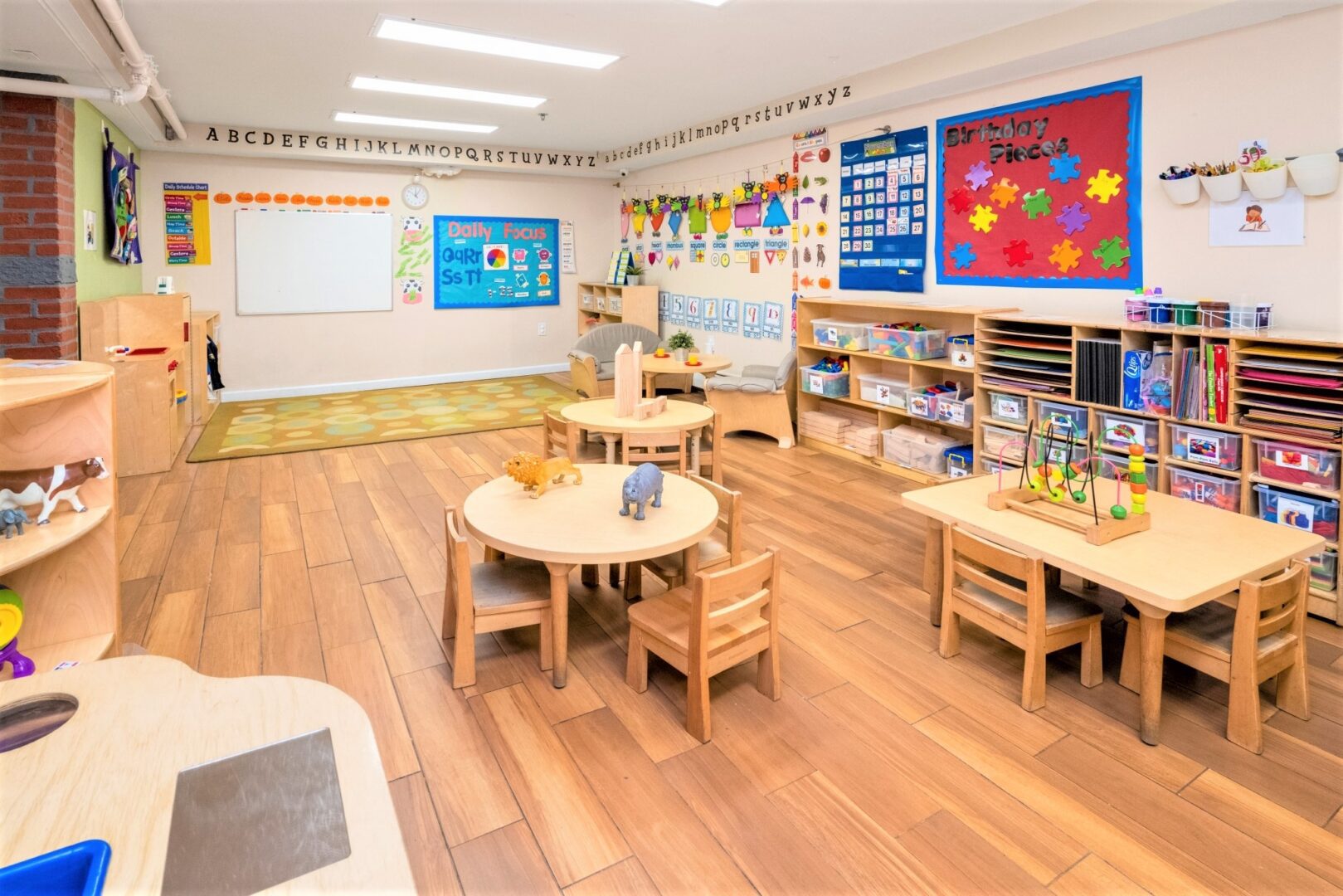 Pre-K classroom at Smart Start Academy with alphabet frieze and stocked supply shelving