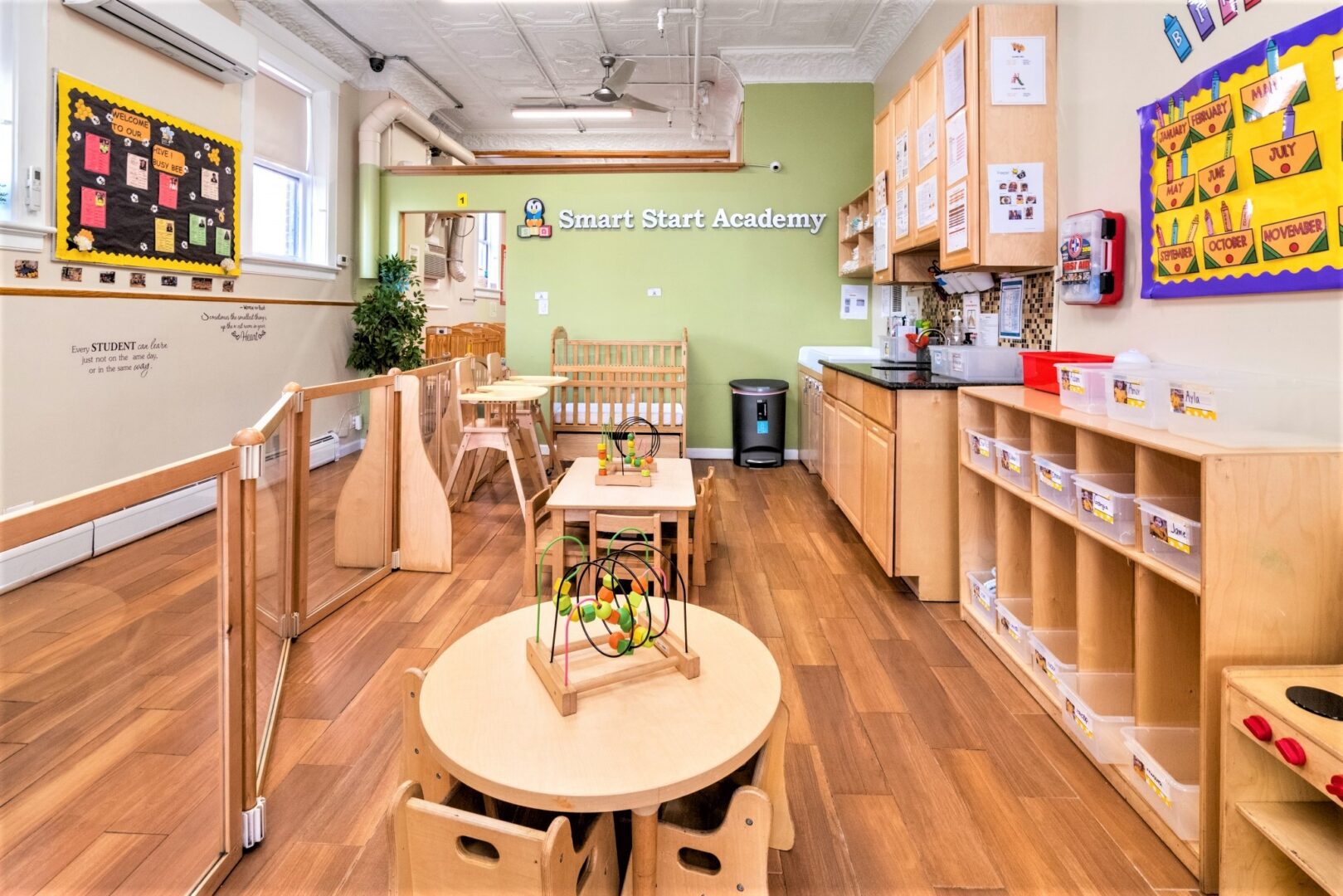 Toddler classroom at Smart Start Academy with labeled cubbies and safety gating