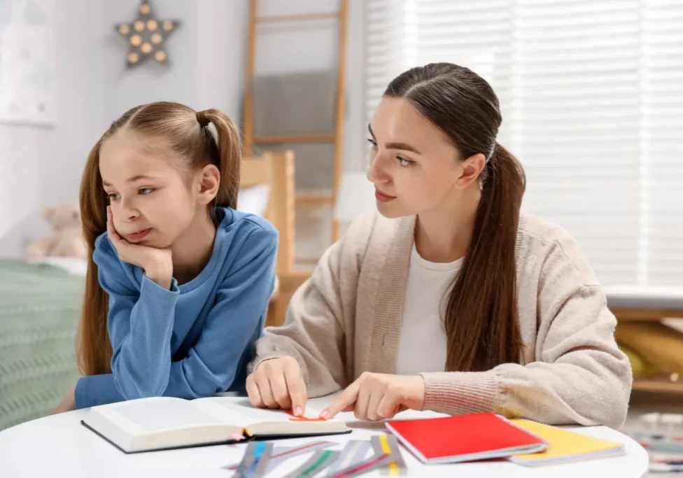 Woman helping girl with homework
