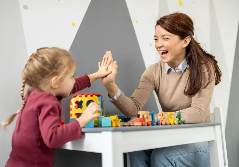 Preschooler and teacher sharing a high five